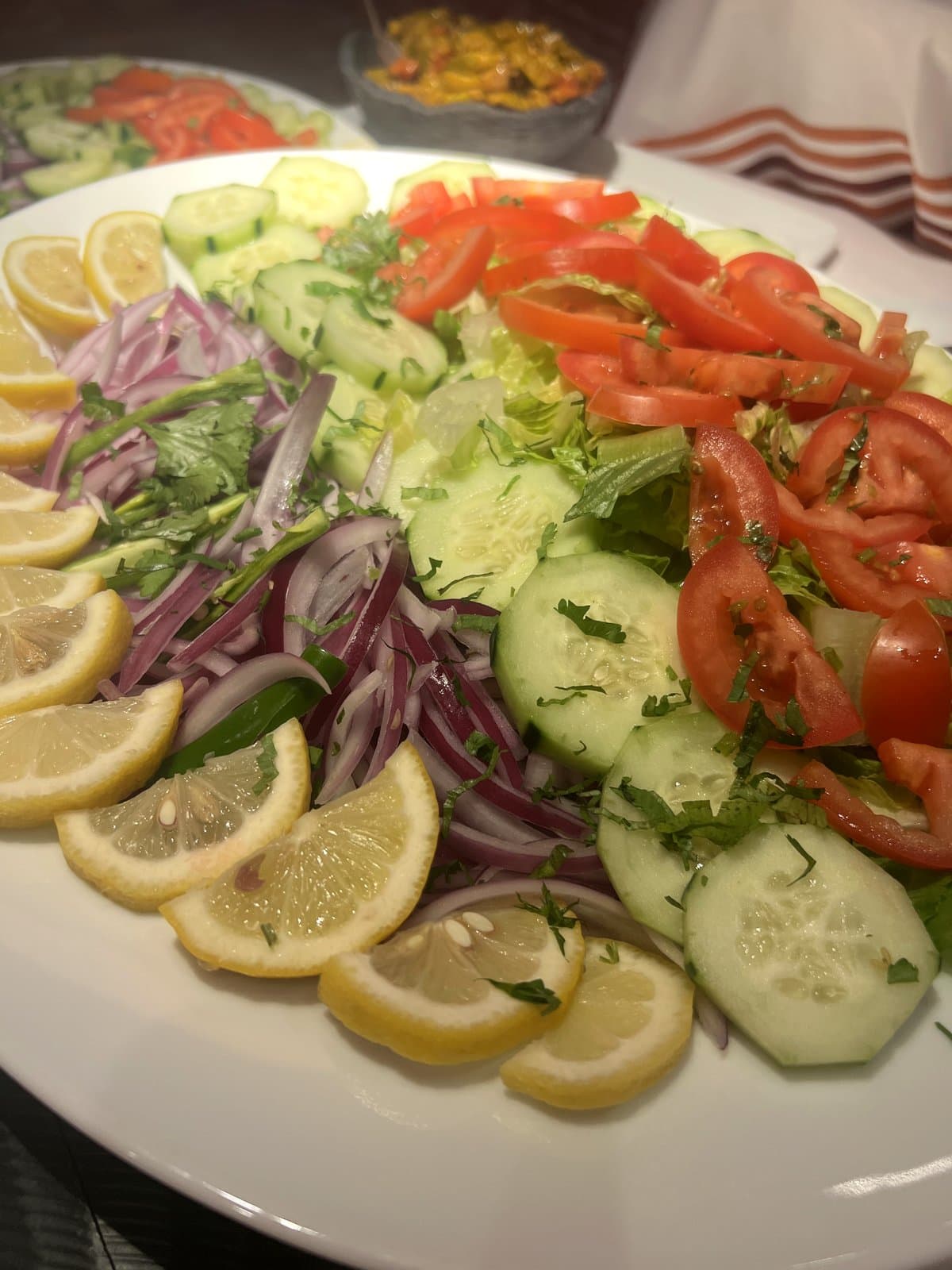 Fresh garden salad platter with cucumbers, tomatoes, and onions at Mint catering