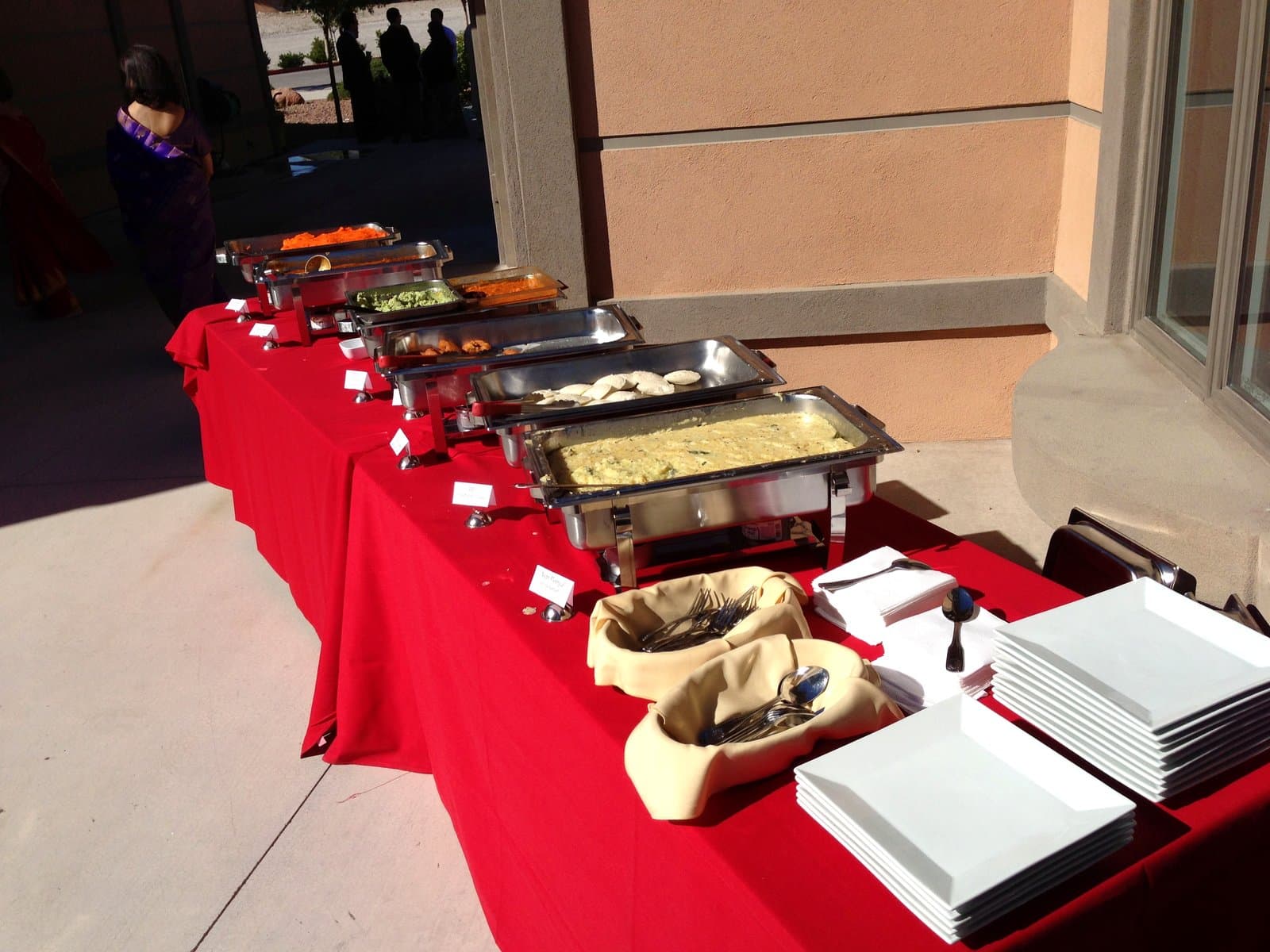 Outdoor buffet service with labeled chafing dishes at Mint Indian Bistro catering