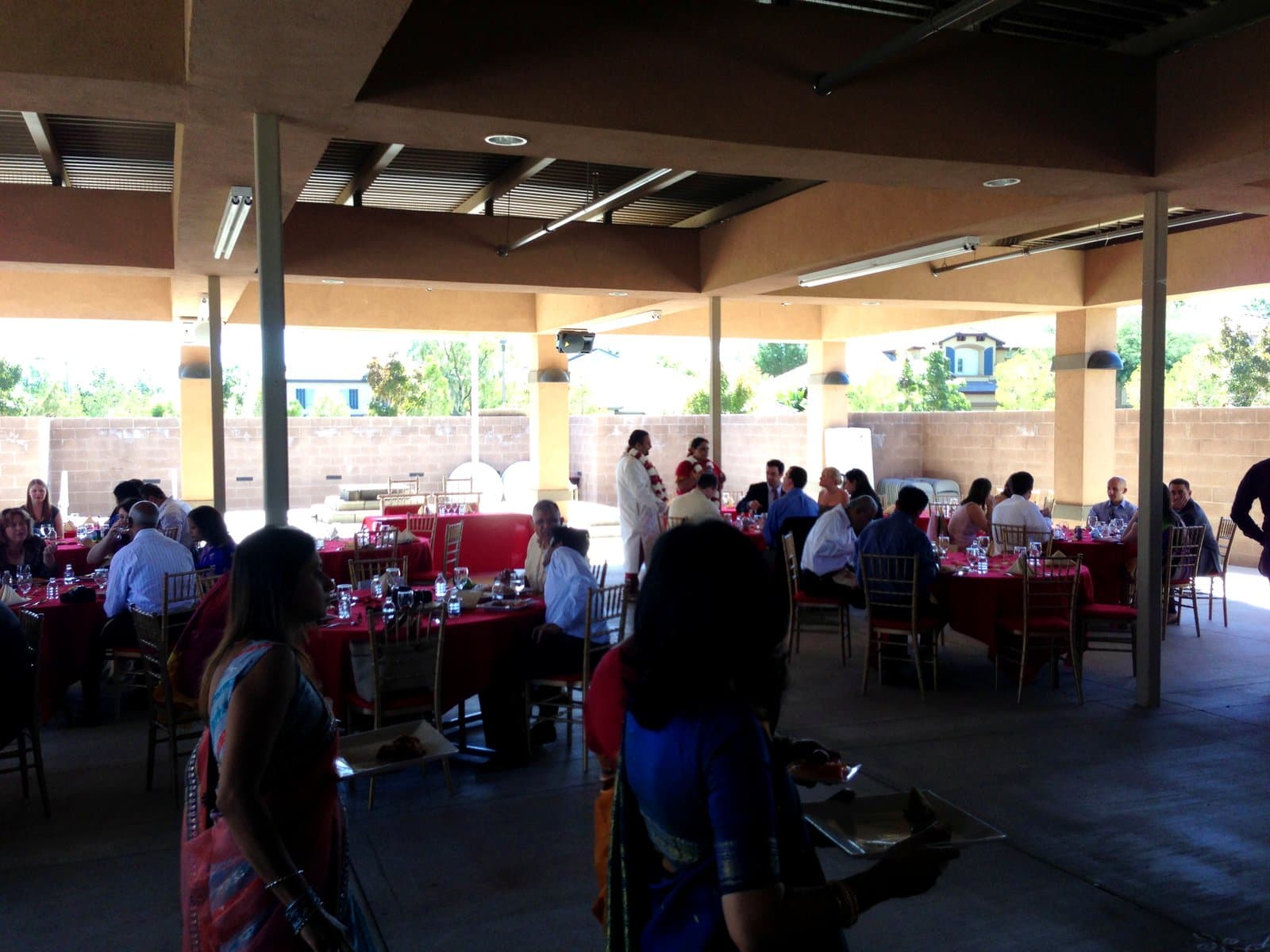 Outdoor wedding reception with red table linens catered by Mint Indian Bistro