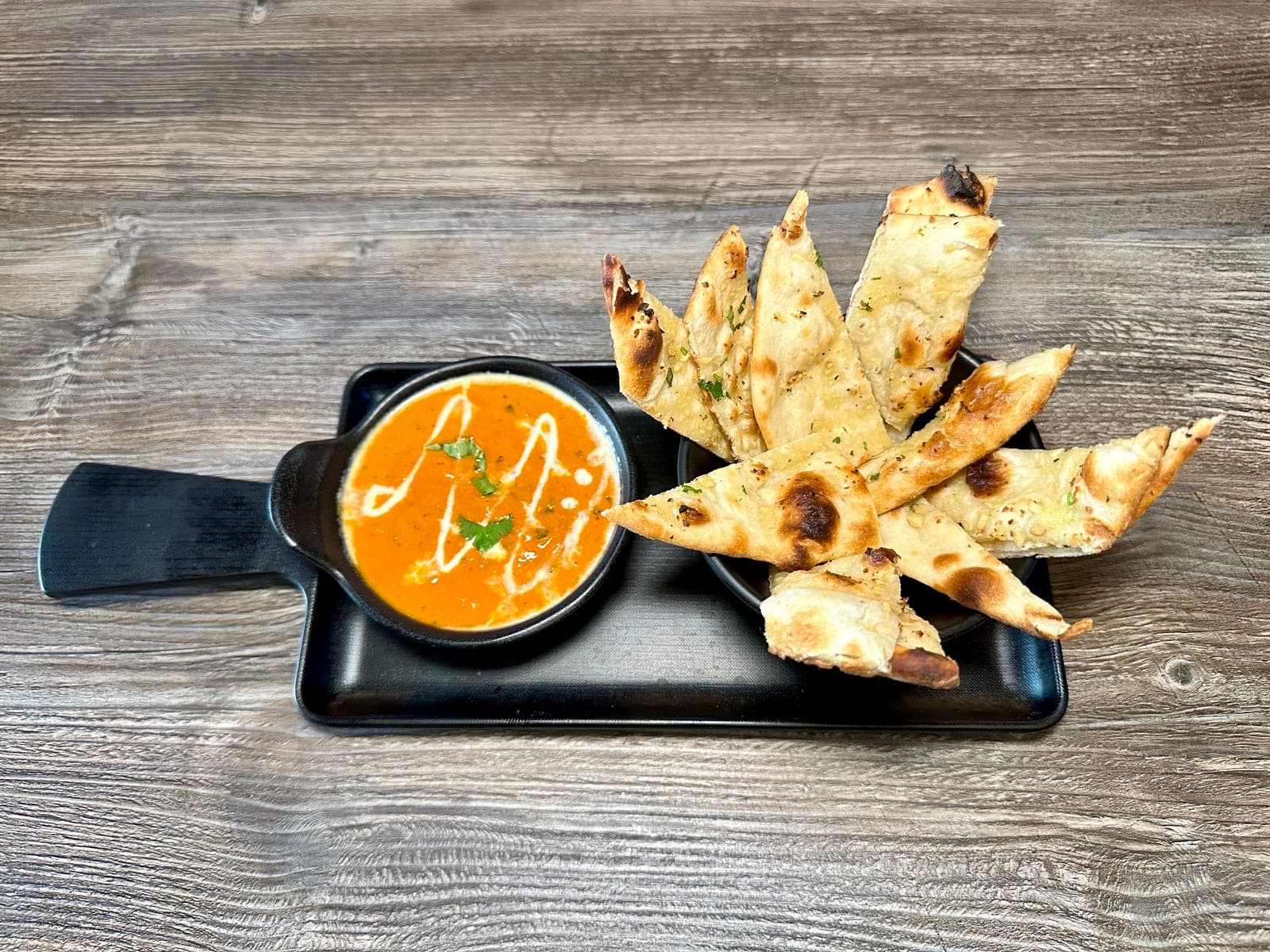 Naan makhani with creamy curry at Mint Indian Bistro